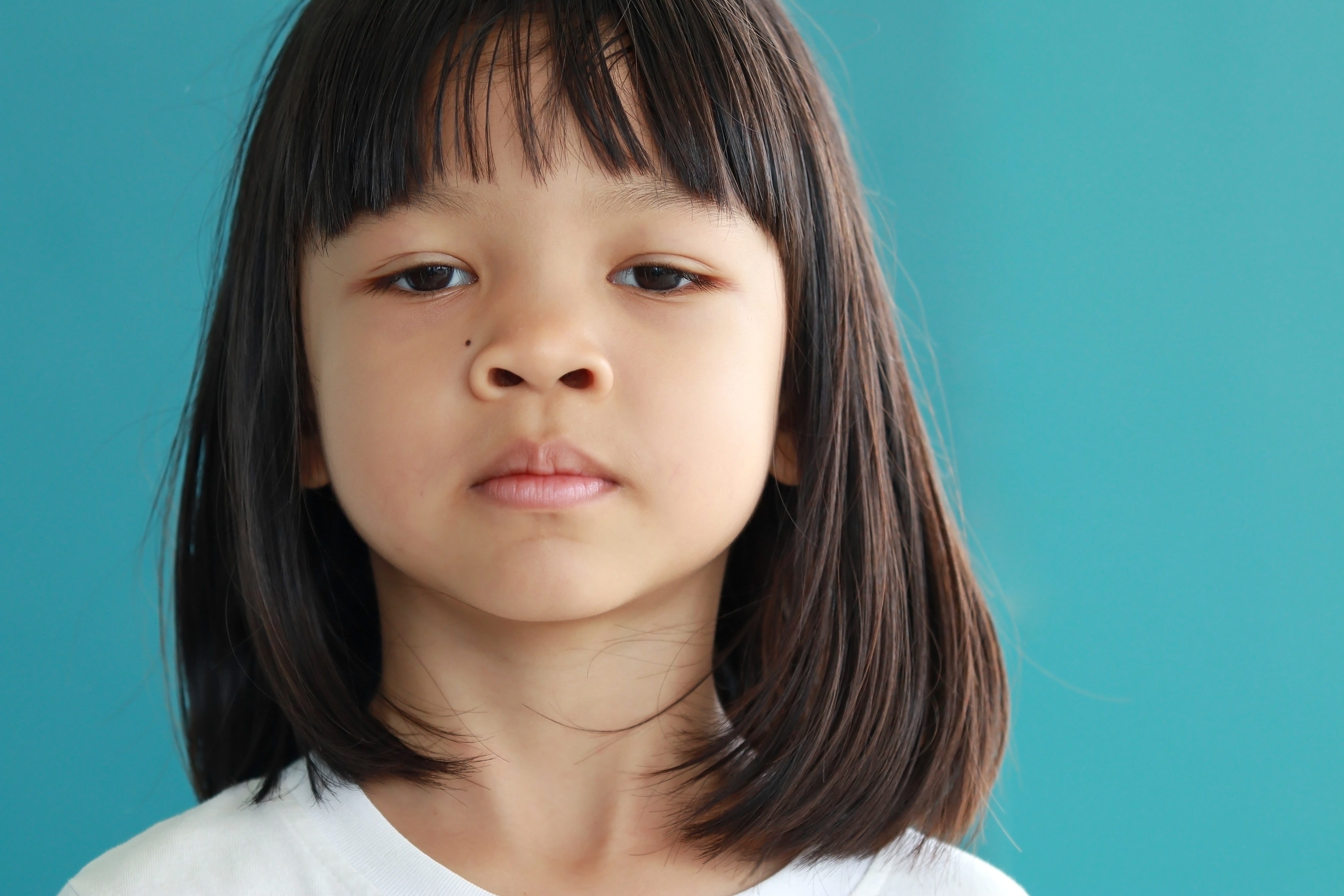 Portrait of Thai young girl with cute face, long hair, not smiling, showing thinking.